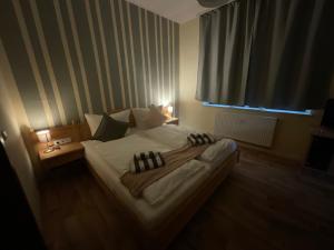 a bedroom with a large bed with two lights on it at Pension Lindenhof in Dresden