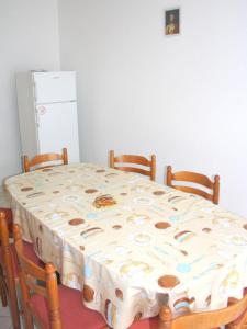 einen Tisch und Stühle mit einem Tisch und einem Kühlschrank in der Unterkunft Apartments Ivan in Crikvenica