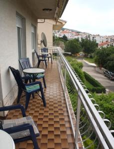 eine Terrasse mit Stühlen und Tischen auf dem Balkon in der Unterkunft Apartments Ivan in Crikvenica