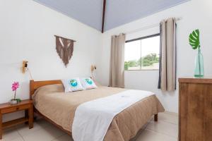 布希奧斯的住宿－Arpoador Apts Praia & Piscina - Buzios Rentals，一间卧室设有一张床和一个窗口