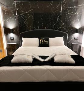a bedroom with a white bed with a black wall at Real suite spa in Palermo