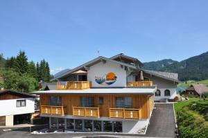 un edificio con un cartel en el costado en Morgenfurt - Appartements 3 Sterne und Erdhäuser 4 Sterne in Alleinlage en Weissensee