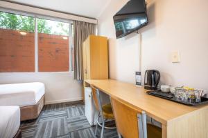 a room with a tv and a desk at Meadow Inn Hotel-Motel in Melbourne