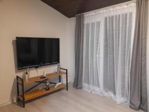 sala de estar con TV de pantalla plana y ventana en Luxury Duplex in the Center of Alsancak, en Konak