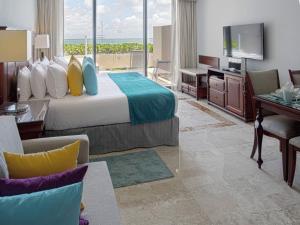 a hotel room with a bed and a television at Paradisus Cancun All Inclusive in Cancún