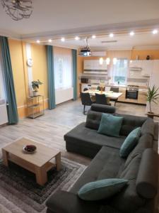 sala de estar con sofá y mesa en Pilis Apartman, en Piliscsaba