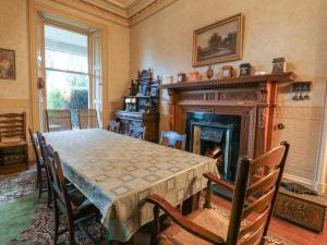 a dining room with a table and a fireplace at Woodside House in Arbroath