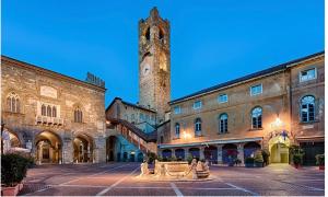 a large building with a clock tower in the background at Rial Maison in Bergamo