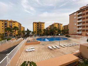 a swimming pool with lounge chairs and buildings at CASA ROBERTO CANDELARIA,PARKING,AIR,WIFi in Candelaria