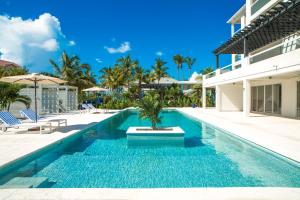 a swimming pool next to a building with a resort at The Tides, Grace Bay in Providenciales