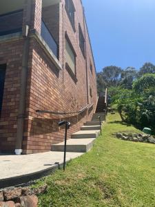 a brick building with stairs next to a building at Panoramata @ Caves Beach in Caves Beach