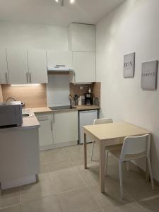 a kitchen with white cabinets and a table and chairs at Villafranca in Villefranche-sur-Mer