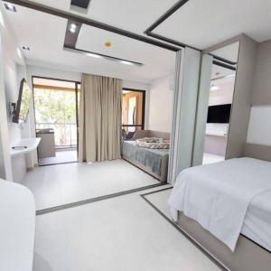 a bedroom with a bed and a mirror at LINDO Flat Eco Resort - melhor trecho da praia de Carneiros in Praia dos Carneiros