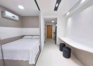 um quarto com uma cama branca e um espelho em LINDO Flat Eco Resort - melhor trecho da praia de Carneiros em Praia dos Carneiros