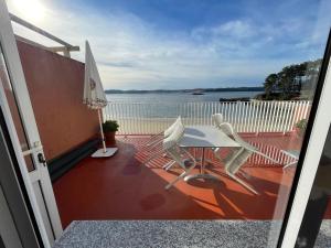 a balcony with a table and chairs and a view of the water at Oktheway Perbes Beach Vintage in Boebre