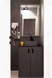 un baño con lavabo y espejo en Rock n Rome - Piazza di Spagna - Via del Babuino, en Roma
