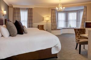 1 dormitorio con 1 cama blanca grande y 1 silla en Best Western Plus Kenwick Park Hotel, en Louth