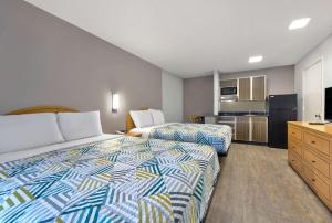 a hotel room with two beds and a kitchen at Studio 6-North Richland Hills, TX - Fort Worth in North Richland Hills
