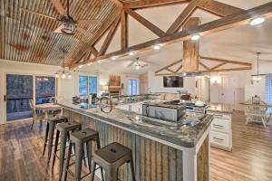 a large kitchen with a large counter with stools at 15 Mi to Hot Springs Natl Park Home with Fire Pit! in Hot Springs Village