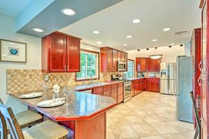 a large kitchen with wooden cabinets and a large island at Pet-Friendly La Quinta Gem with Pool and Yard Games in La Quinta