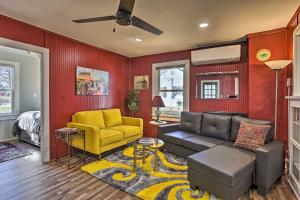 a living room with a couch and a yellow chair at Homey Cottage with Sunroom and Smart TV! 