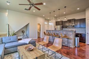 a living room with a blue couch and a bar at Edmond Oasis with Rooftop Lounge Walk to Dtwn! in Edmond