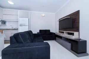 sala de estar con sofá y TV de pantalla plana en Casa à 80m da praia, en Bombinhas