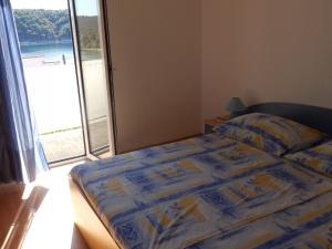 ein Schlafzimmer mit einem Bett und einem großen Fenster in der Unterkunft Apartment Ren - 150m from beach in Kampor