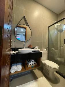 La salle de bains est pourvue d'un lavabo, de toilettes et d'un miroir. dans l'établissement Pousada Júlio Grande, à Fernando de Noronha
