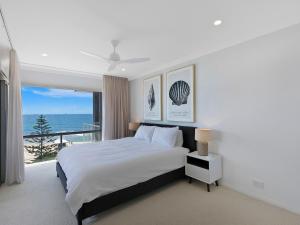 a white bedroom with a bed and a large window at Dolphin Court Penthouse in The Entrance