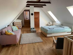 a attic bedroom with a bed and a couch at Statek Keblice in Keblice