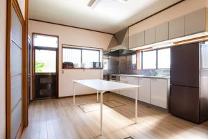 una cocina con una mesa blanca en el medio. en 古民家再生ホテル　Relink, en Fujiyoshida