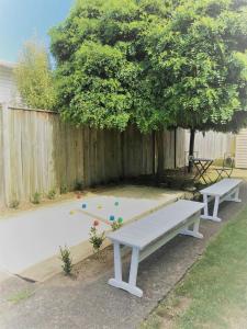 un banc de pique-nique dans une cour arrière avec une clôture dans l'établissement Strasbourge Cottage, à Martinborough
