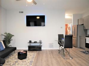 a living room with a couch and a tv on a wall at Rare Vibrant Hidden Gem - 2 Mins from Downtown in Dallas
