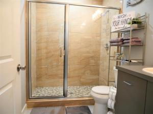 a shower with a glass door in a bathroom at Rare Vibrant Hidden Gem - 2 Mins from Downtown in Dallas