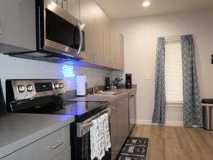 a kitchen with a stove and a microwave at Rare Vibrant Hidden Gem - 2 Mins from Downtown in Dallas