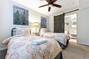 two beds in a bedroom with a ceiling fan at Starfall in Yosemite West