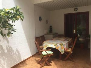 a dining room with a table and two chairs and a table and a plant at Lovely family apartment in high quality residence in Palm-mar