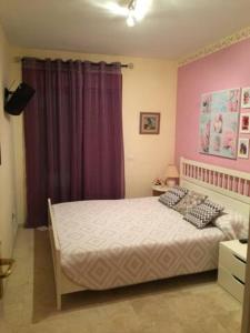 a bedroom with a bed and a purple curtain at Lovely family apartment in high quality residence in Palm-mar