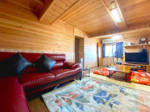 a living room with a red couch and a tv at 普光寺 in Kawaba