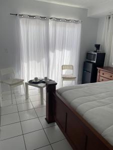 a bedroom with a bed and a table and chairs at elegant room in Tamiami