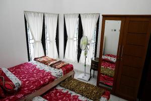 Posteľ alebo postele v izbe v ubytovaní Grand Purwomartani Homestay Jogja