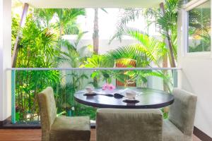 a table and chairs in a room with a large window at Davina Beach Homes in Panwa Beach