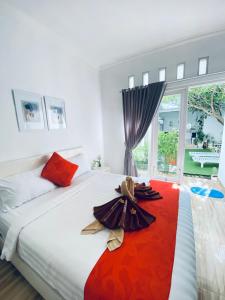 a bedroom with a large bed with a red blanket at Umah Putih in Nusa Penida