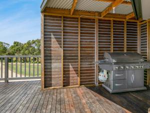 a barbecue on a wooden deck with a fence at Bass River Farm in Bass