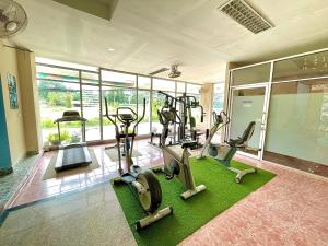 a gym with treadmills and ellipticals in a room at Green Beach Pattaya in Pattaya North