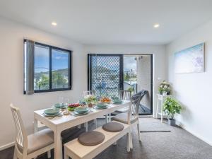 Un comedor con una mesa y sillas blancas. en Dolphin Cove 8, 2-6 Government Rd - Air conditioning, Wi-Fi, lift, secure parking and close to town, en Nelson Bay