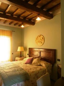 a bedroom with a bed with a wooden headboard and a window at Tenuta Colverano in Montefalco
