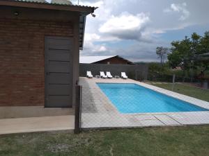 聖羅莎德克蘭穆齊塔的住宿－Cabañas Quimera，房屋旁带椅子的游泳池