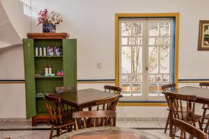 a dining room with a table and chairs and a window at Pousada da Tina in Ubatuba